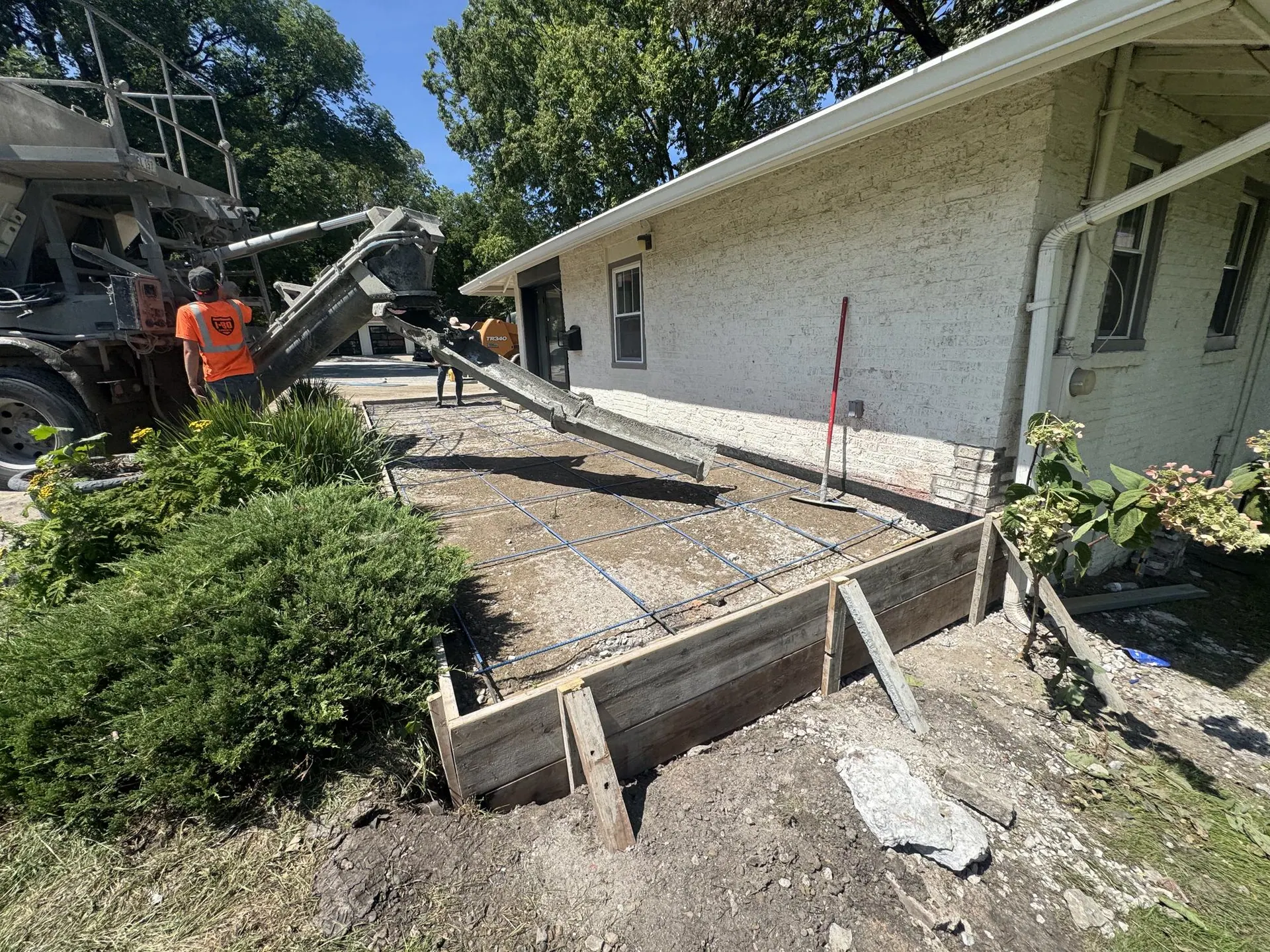 Concrete truck chute pouring into the forms.