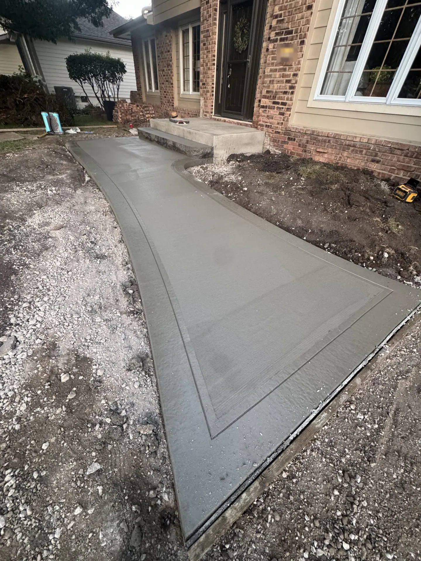 Curved concrete walkway and steps on the day of the pour.